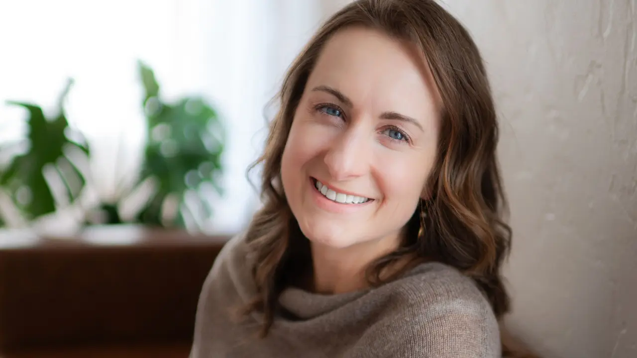 Shannon Kossick, LCSW, LCADC, trauma therapist in Carson City, Nevada, smiling in her therapy office. Play introduction video.
